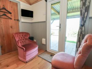 a living room with a pink chair and a window at Golden Fleece in Macclesfield