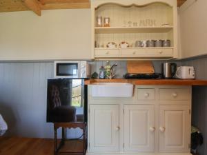 a kitchen with white cabinets and a sink and a microwave at Golden Fleece in Macclesfield