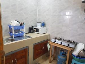 a small kitchen with a sink and a microwave at Résidence BEDEL in Yamoussoukro