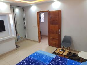 a room with a bed and a chair and a door at Résidence BEDEL in Yamoussoukro +1 photo