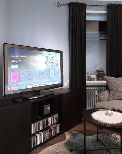 a living room with a flat screen tv and a couch at Maries bunte Villa in Bad Berleburg