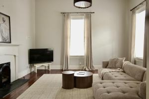 a living room with a couch and a tv at Macons Historic Tatnall Home in Macon
