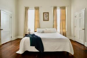 a bedroom with a large bed with a black blanket on it at Macons Historic Tatnall Home in Macon