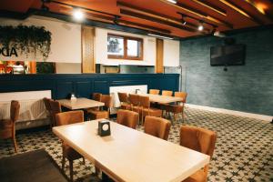 a restaurant with tables and chairs and a flat screen tv at Zlagoda in Ternopil