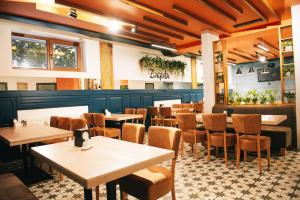 a dining room with tables and chairs in a restaurant at Zlagoda in Ternopil