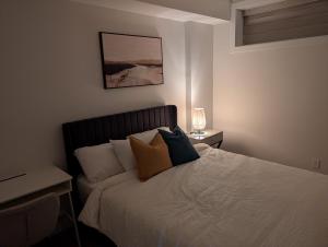a bedroom with a bed with pillows on it at Granny's Hug, a cozy 2 Bedroom Basement Suite in Calgary
