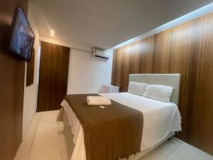 a hotel room with a bed and a television at Pousada Corais de Pajuçara- MCZ in Maceió