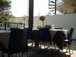 a table with blue chairs and a table at Hotel Noto Marina Scirocco & SPA in Noto Marina