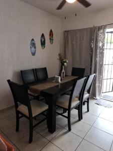 a dining room with a wooden table and chairs at Casa Atardecer - Privada Los Olivos in Playa del Carmen