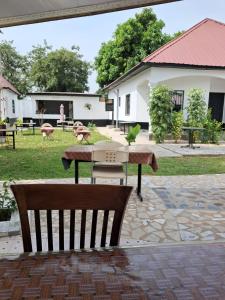 a patio with a table and a bench in a yard at Maria's place in Tujering