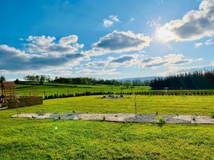 a field with a fence in the middle of it at Polny Domek in Bystrzyca Kłodzka