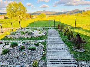 a garden with a wooden pathway in a field at Polny Domek in Bystrzyca Kłodzka