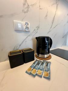 a table with a coffee maker and some donuts at Apartments Piotrkowska 67 in Łódź