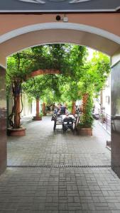an archway with people sitting at tables under trees at Apartments Piotrkowska 67 in Łódź
