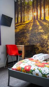 a bedroom with a bed and a red chair at Igloo Hybrid in Nottingham