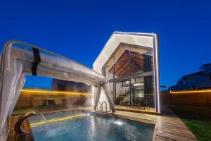 a swimming pool in front of a house at Rubis Villa Bungalov in Elmalık