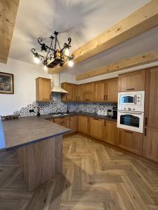 a large kitchen with wooden cabinets and a counter top at Pensiunea Sub Ursoi in Ieud +33 photos