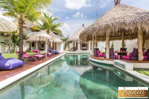 a swimming pool with chairs and a resort at Villa Kaaiti in Uluwatu