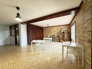 a room with tables and chairs and a brick wall at Casa Ángel 1982 in Oia