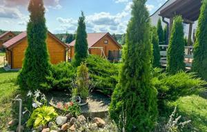 a garden with trees and plants in front of a house at Amazing Home In Rybical With Wifi in Rybical +5 photos