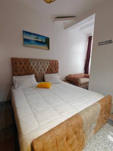 a bedroom with a large bed with a tufted headboard at TANG HOSPITALITY Services in Gisenyi +1 photo
