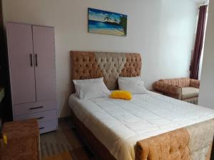 a bedroom with a large bed and a dresser at TANG HOSPITALITY Services in Gisenyi