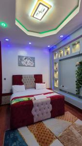 a bedroom with a bed in a room with purple lighting at TANG HOSPITALITY Services in Gisenyi