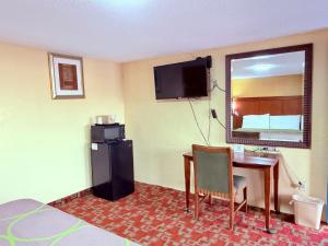 a hotel room with a desk and a television at Aloha Inn McAllen Airport near Medical center Tx in McAllen