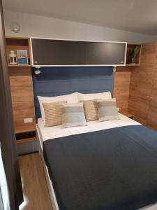 a bedroom with a large bed with a blue headboard at Max Mobile Home in Biograd na Moru
