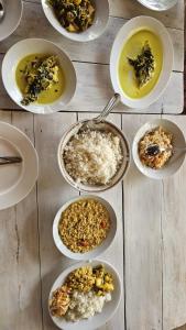 a table topped with plates of different types of food at Nimal's white house in Nilaveli
