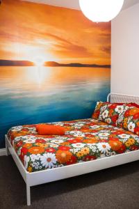 a bedroom with a bed with a painting of the ocean at Igloo Hybrid in Nottingham