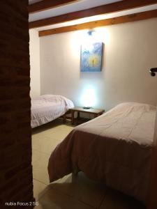 a bedroom with two beds and a table with a lamp at Complejo Rancho Grande in Nueva Atlantis