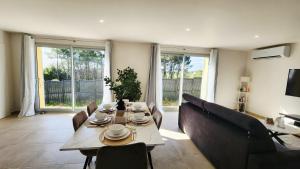 a living room with a table and a couch at La maison des Vignes est climatisée avec ménage, draps et serviettes inclus in Tabanac