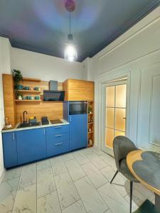 a kitchen with blue cabinets and a table at Euphoria Apartments in Beiuş