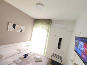 a room with a bed and a tv and a window at B&B Alle porte del centro in Santa Maria Capua Vetere