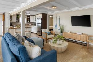 a living room with blue couches and a kitchen at The Edgewater Condos by AvantStay in Newport Beach