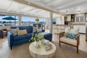 a living room with a blue couch and a table at The Edgewater Condos by AvantStay in Newport Beach