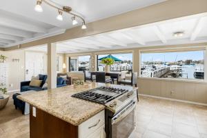 a kitchen and living room with a view of a marina at The Edgewater Condos by AvantStay in Newport Beach