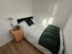 a bedroom with a large bed and a night stand at Double Room - Central Dartford - Free Parking in Dartford