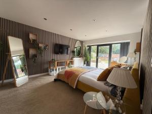 a bedroom with a bed and a mirror and a tv at Lincoln 4-Beds Sleeps 13 Hot Tub & Pet Friendly in Lincoln