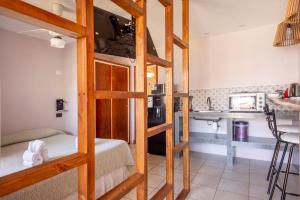 a room with a bunk bed and a kitchen at Hotel Rideamus in Villa Gesell