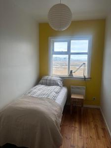 a bedroom with a bed and a window at Grjótá Historical countryhouse in Hvolsvöllur
