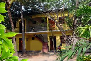 une maison jaune avec un escalier devant elle dans l'établissement Hotel Pearl Gate, à Chilaw