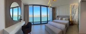 ein Schlafzimmer mit Bett und Meerblick in der Unterkunft Beachfront Villa with Heated Private Pool & Jacuzzi in Al Ḩamrīyah + 36 Fotos