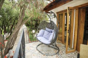 a wicker chair with a purple pillow sitting on a porch at Hotel Oviedo Teotihuacán in San Martín de las Pirámides
