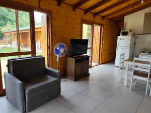 a living room with a chair and a tv and a kitchen at Cabaña la Tijereta del Iporá in Balneario Ipora