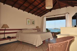 a bedroom with a bed with a view of the ocean at Aguabúzios Hotel in Búzios +79 photos