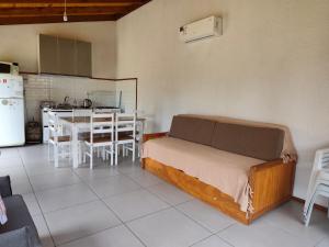 a bedroom with a bed and a kitchen with a table at Cabaña la Tijereta del Iporá in Balneario Ipora