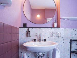a pink bathroom with a sink and a mirror at Hôtel historique Chez Elsy - Crans-Sapins in Crans-Montana +30 photos