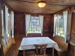 ein Esszimmer mit einem Tisch und zwei Fenstern in der Unterkunft Reschbauer in Mainsdorf